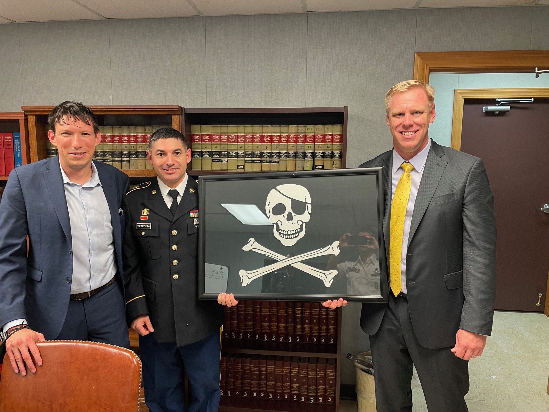 Tim Bilecki and Ben Gold stand with a client holding a pirate flag.