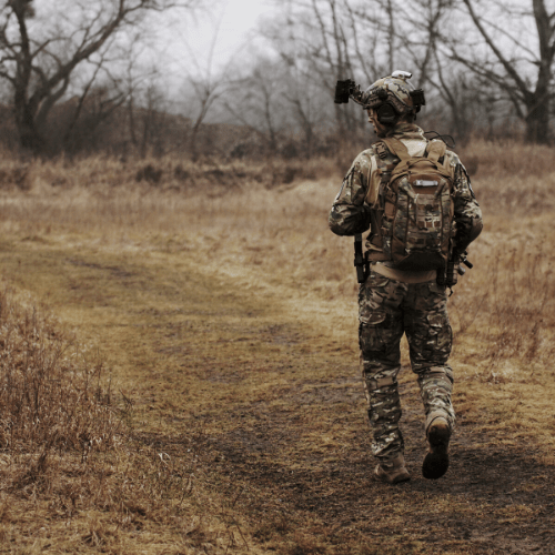 A soldier walking in a field alone